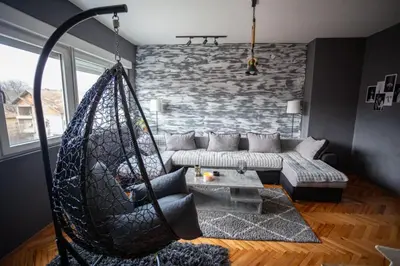 a hammock in a living room with a stone wall at Fenix1 in Knjazevac.