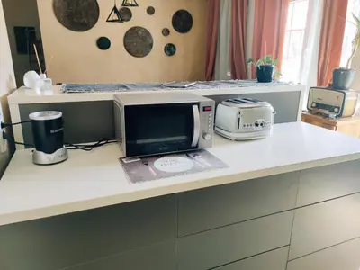 a kitchen counter with a microwave and a computer on it at Nirvana apartment in Niš