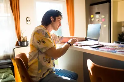 a man sitting at a desk with a laptop computer at Nirvana apartment in Niš