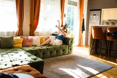 a woman sitting on a couch in a living room at Nirvana apartment in Niš