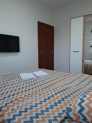 a bedroom with a bed and a flat screen tv at Apartman Milic Pirot-Zapadni Kej 10 in Pirot