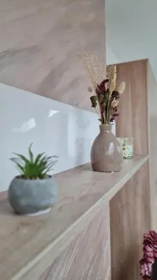 a vase with flowers sitting on a wooden shelf at Apartman Marija in Soko Banja