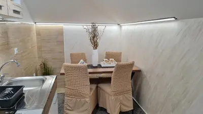 a dining room table with chairs and a sink at Apartman Marija in Soko Banja