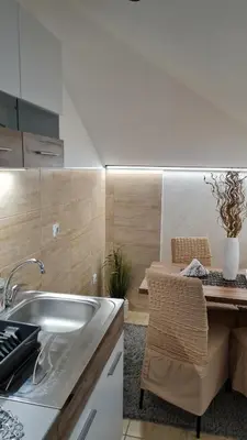 a kitchen with a sink and a table with a dining room at Apartman Marija in Soko Banja