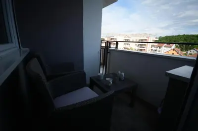 a room with a balcony with a chair and a table at Apartman Elena 14 in Vrnjačka Banja