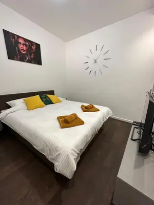 a bedroom with a bed with a clock on the wall at DREAM apartments in Niš