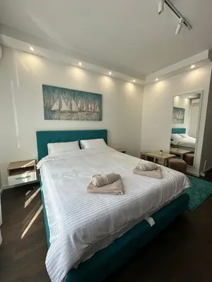 a bedroom with a large bed with two towels on it at DREAM apartments in Niš
