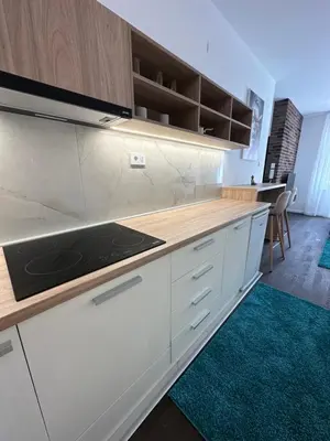 a kitchen with white cabinets and a counter top at DREAM apartments in Niš
