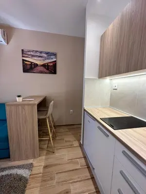 a small kitchen with a table and a desk at DREAM apartments in Niš