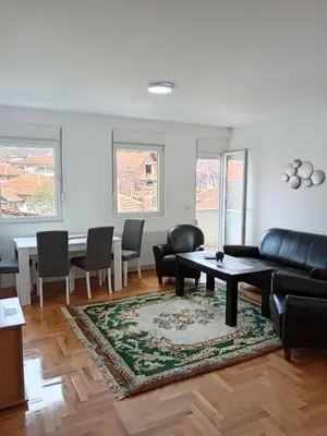 a living room with a couch and a table and chairs at Nikolici - Free Parking in Vranje