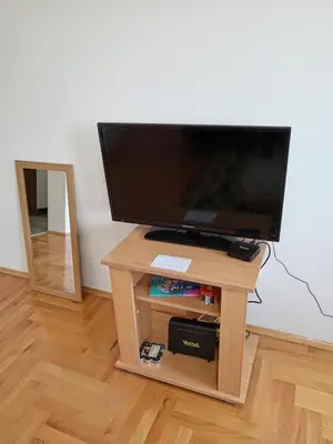 a television on a wooden table with a mirror at Nikolici - Free Parking in Vranje