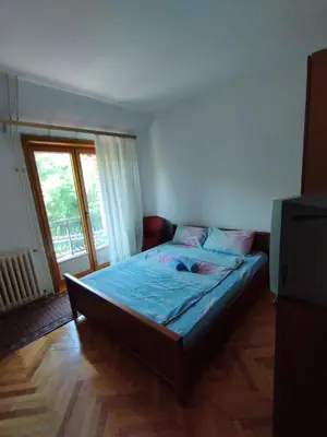 a bedroom with a bed with blue sheets and a window at VILA MARKO in Niška Banja