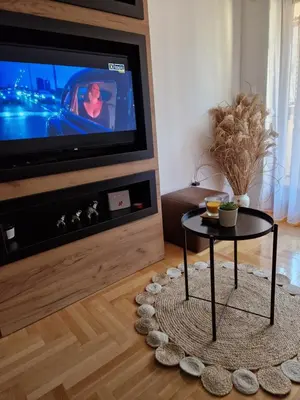 a living room with a table in front of a tv at Apartman Bošković Vrnjačka Banja in Vrnjačka Banja