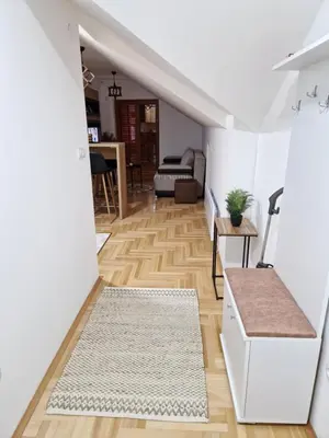 a living room with white walls and wooden floors at Apartman Bošković Vrnjačka Banja in Vrnjačka Banja