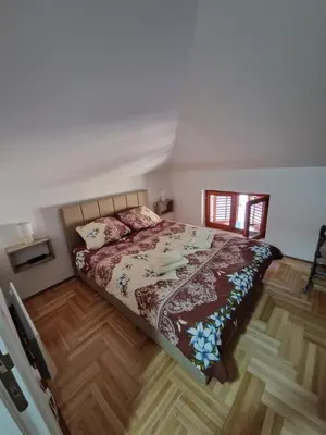 a bedroom with a bed and a wooden floor at Apartman Bošković Vrnjačka Banja in Vrnjačka Banja