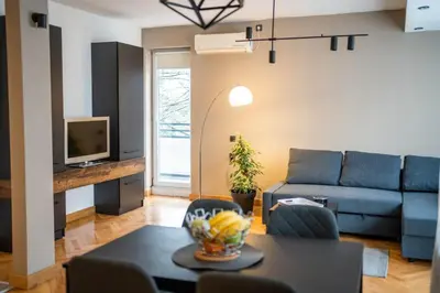a living room with a blue couch and a table at Dora in Bor