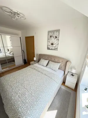 a bedroom with a large bed and a mirror at Aleksandar apartman Sokobanja in Soko Banja