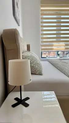 a bedroom with a bed with a chair and a lamp at Aleksandar apartman Sokobanja in Soko Banja