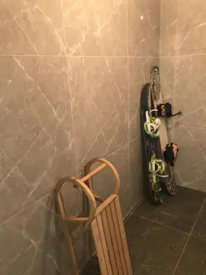 a wall with a snowboard and a chair in a room at Pekakop Treska in Kopaonik