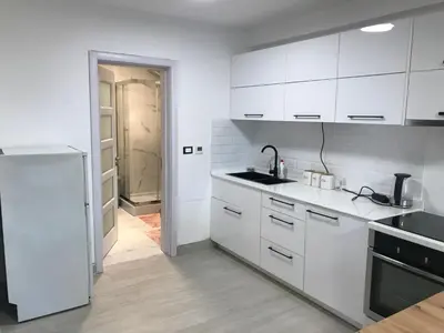 a white kitchen with a sink and a refrigerator at Pekakop Treska in Kopaonik
