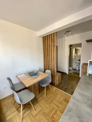 a dining room with a wooden table and chairs at APARTMAN TAMARA LUX in Vrnjačka Banja