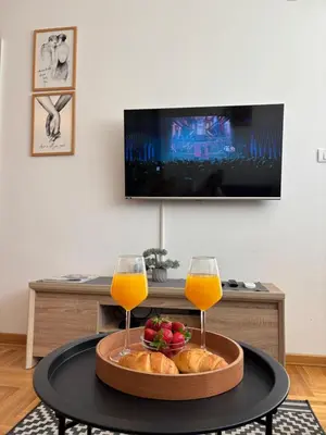a table with two glasses of orange juice and bread at Sweet Dreams & Free parking in Vrnjačka Banja