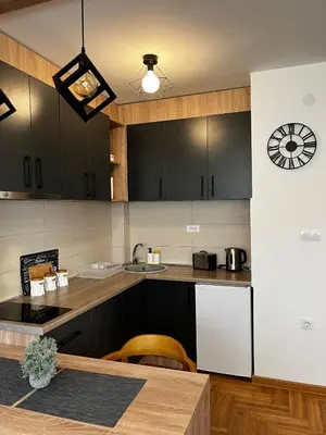 a kitchen with black cabinets and a counter top at Sweet Dreams & Free parking in Vrnjačka Banja