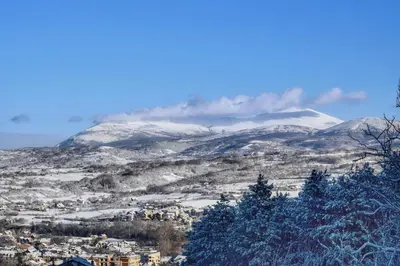 a city with snow covered mountains in the background at Apartman Borići in Soko Banja