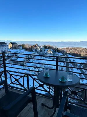 a table and chairs on a balcony with a view at Milmari Apartments & SPA - N Lux 108 in Kopaonik
