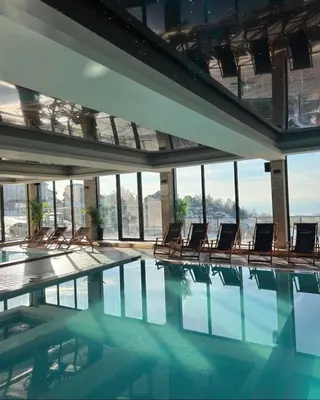 a swimming pool with chairs in a building at Milmari Apartments & SPA - N Lux 108 in Kopaonik