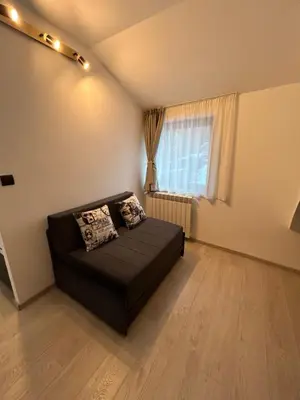 a black couch in a room with a window at Milmari Apartments & SPA - N Lux 108 in Kopaonik
