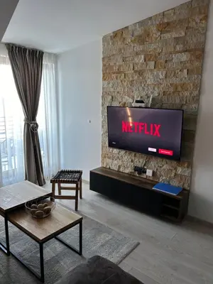 a living room with a tv on a brick wall at Milmari Apartments & SPA - N Lux 108 in Kopaonik
