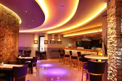 a restaurant with tables and chairs and a bar at Hotel Petrus in Paraćin