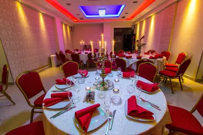 a large dining room with tables and red chairs at Hotel Petrus in Paraćin