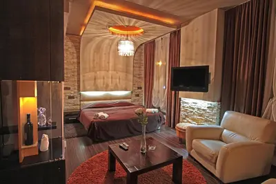 a bedroom with a bed and a couch and a table at Hotel Petrus in Paraćin