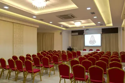a conference room with red chairs and a table at Hotel Petrus in Paraćin