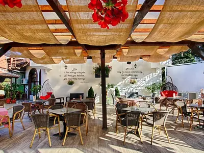 a restaurant with tables and chairs under umbrellas at Hotel Petrus in Paraćin