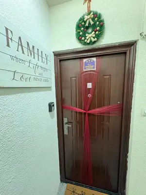 a door with a christmas wreath on the wall at Family Apartment in Niš