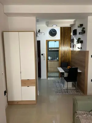 a living room with a table and a dining room at Family Apartment in Niš