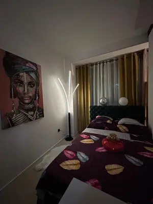 a bedroom with a bed with a table with cookies on it at Family Apartment in Niš