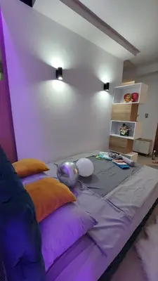 a bed with purple and orange pillows in a room at Family Apartment in Niš