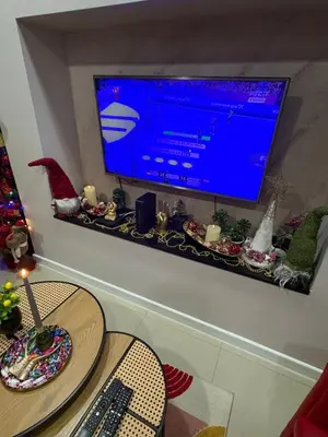 a living room with a tv on a wall with a table at Family Apartment in Niš