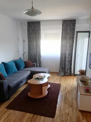 a living room with a blue couch and a table at Apartman BojAna Vrnjačka Banja in Vrnjačka Banja