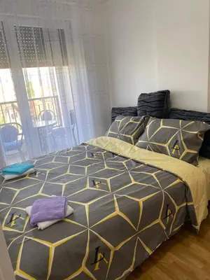 a bedroom with a bed with a black and yellow comforter at Apartman BojAna Vrnjačka Banja in Vrnjačka Banja