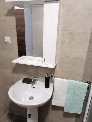 a bathroom with a sink and a mirror and towels at Apartman BojAna Vrnjačka Banja in Vrnjačka Banja