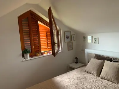 a bedroom with a bed and a window at Vrnjački apartman in Vrnjačka Banja