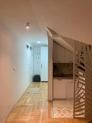 a kitchen with a staircase in the middle of a room at Vrnjački apartman in Vrnjačka Banja