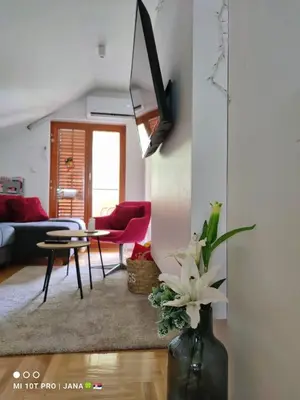 a living room with a vase with flowers in it at Vrnjački apartman in Vrnjačka Banja