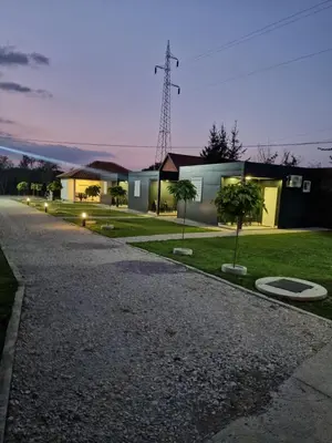 a driveway with a house and some trees and lights at Đerdan Garden apartments in Kraljevo