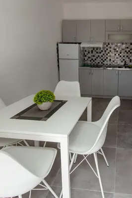 a white table and chairs in a kitchen at Đerdan Garden apartments in Kraljevo